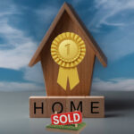 Award ribbon on a wooden house with a sold sign highlighting first-time buyer market trends.