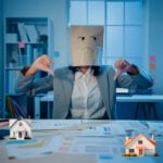 Person at desk with a paper-bag mask giving thumbs down to represent frustration with poor rental conditions