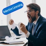 Angry landlord tearing paperwork while reacting to selective licensing concerns