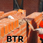 Construction worker laying mortar on a brick wall during discussion of UK build-to-rent growth