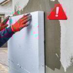 Worker fitting external wall insulation with warning symbol highlighting potential installation faults