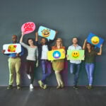 Diverse group of renters holding emoji signs representing positive experiences in the rental sector