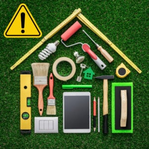 Home improvement tools arranged with a warning symbol to highlight upcoming property standards for landlords