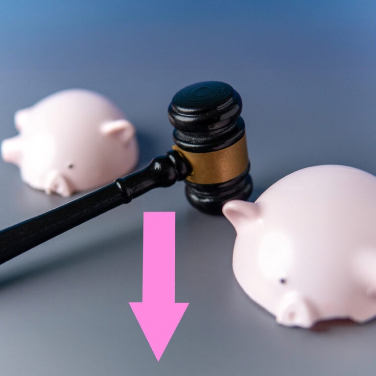 gavel striking between two piggy banks symbolising falling tenancy deposit disputes