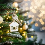 House-shaped ornament and key hanging on a Christmas tree, symbolising home moves and the Boxing Day property market