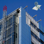 High-rise building with external cladding partially removed during safety inspection and remediation monitoring