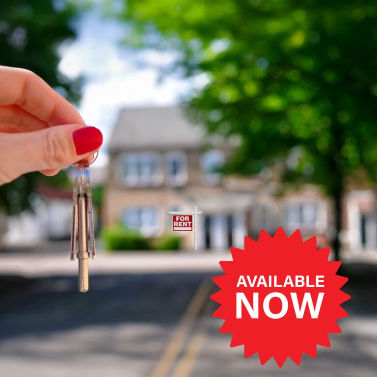 Keys held in front of a rental property with a sign indicating immediate availability