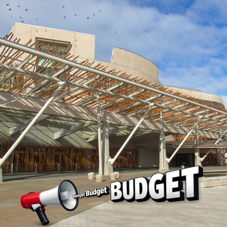 Megaphone projecting the word “Budget” in front of the Scottish Parliament building
