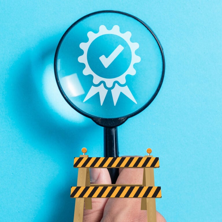 Magnifying glass highlighting a verified badge, symbolising scrutiny of guarantor requirements in renting