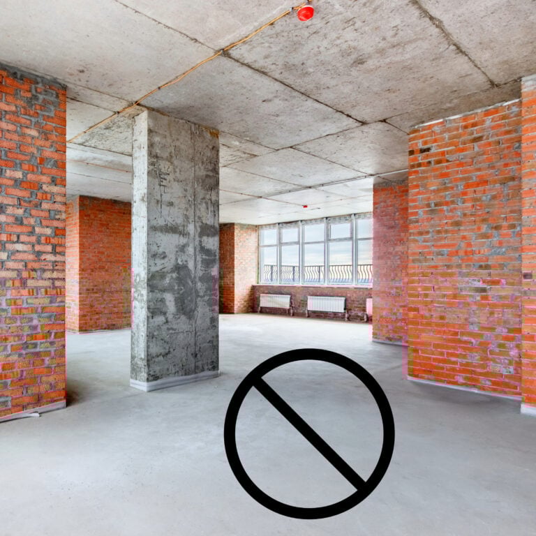 Unfurnished social housing interior with bare concrete floors and no floor coverings