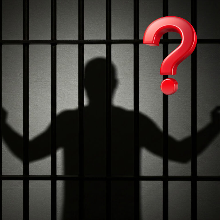 Silhouette of a prisoner behind bars with a red question mark symbolising uncertainty about custody location