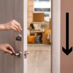 Hand unlocking a door to a home with moving boxes inside, symbolising renting out a spare room to a lodger.