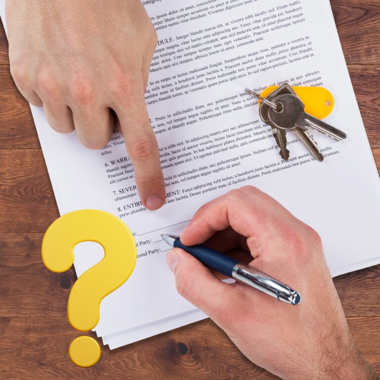 Hands signing a tenancy agreement with keys on the document, highlighting uncertainty over tenant move-out dates.