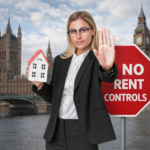 Woman holding a model house and signalling stop beside a “No Rent Controls” sign near the UK Parliament