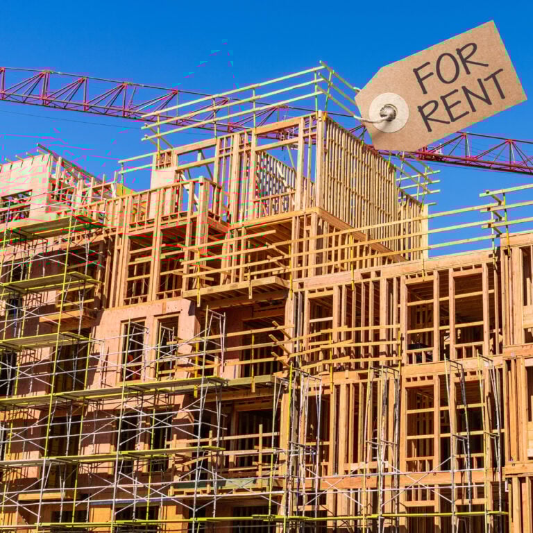 Timber-frame apartment block under construction with crane and “For Rent” sign illustrating growth in build-to-rent housing