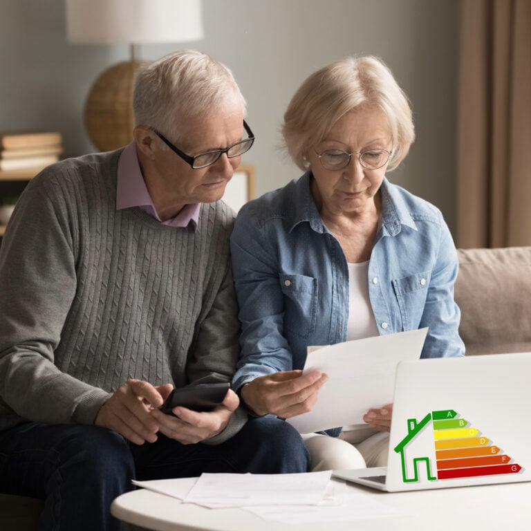 Older couple reviewing household bills and energy efficiency information while discussing housing costs