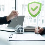 Keys handed over above a rental agreement with a shield icon, illustrating landlord demand for rent guarantors