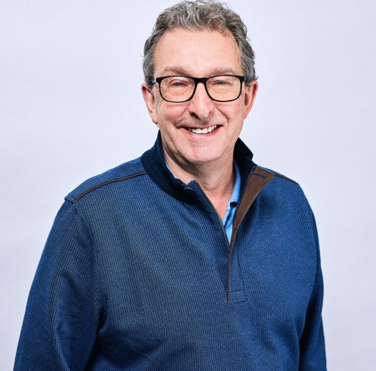 Kevin Shaw from LRG smiling in a blue zip-up jumper against a plain light background.