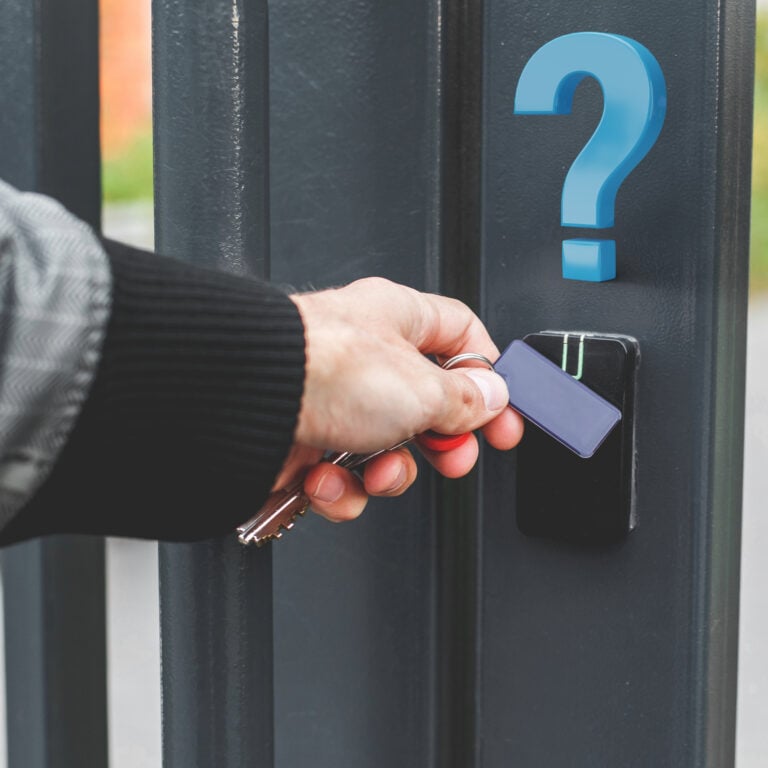 Hand using a key fob on a secure entry system, representing controlled building access and security concerns.