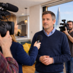 Landlord being interviewed on camera in a London apartment about housing policy changes
