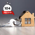 Wooden house keyring beside a key and stopwatch showing 104 days to exchange on UK home sales